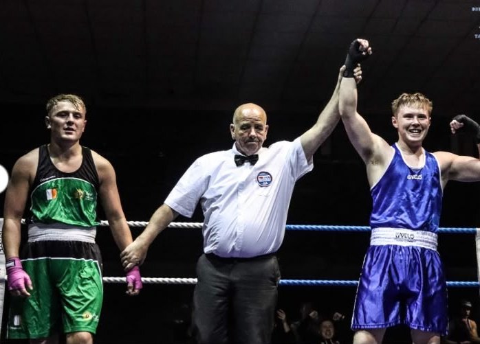 A referee raising the arm of the club's boxer at the end of a bout